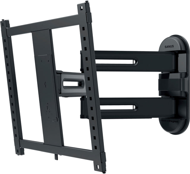 The image features a black SANUS monitor stand, which is designed to hold a flat screen TV. The stand is mounted on the wall, providing a secure and stable support for the TV. The stand is made of metal and has a sleek, modern design that complements the flat screen TV. The stand is adjustable, allowing for easy positioning and viewing angles.