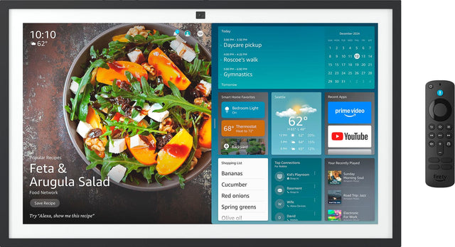 The image shows a computer screen with a variety of information displayed. The main focus is a recipe for Feta & Arugula Salad, which includes a list of ingredients such as bananas, cucumber, red onions, spring greens, olive oil, and other items. The screen also displays a calendar, a shopping list, and a list of top connections. Additionally, there is a section for recent apps, and a popular recipe is featured on the screen. The image also shows a remote control, possibly for a smart home system, and a clo
